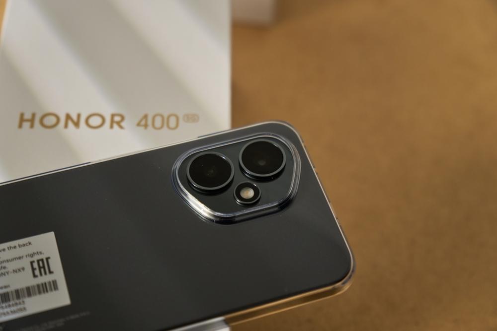 Caja del Honor 400 5G junto al modulo de camara del celular, uno de los celulares en oferta